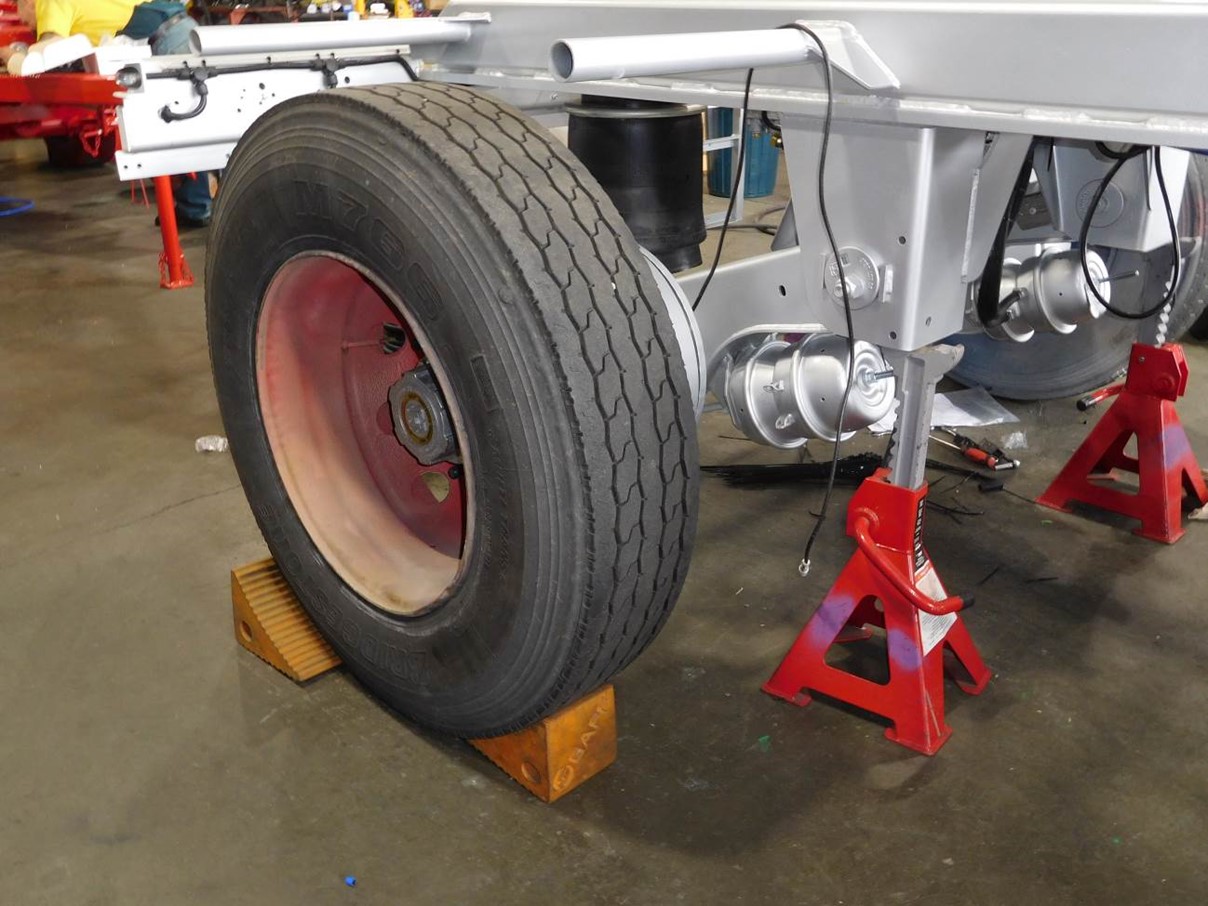 Photo showing safe support of a chassis and axle using stands with wheels and tyres fitted